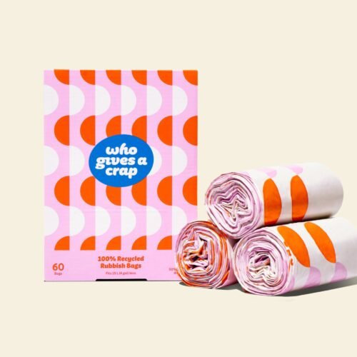 Three rolls of 100% recycled bin bags next to a pink and orange box that contains 60 bags designed to fit 15L bins.